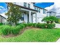 Inviting home with a landscaped front yard, charming porch, and a well-manicured lawn at 21361 Snowy Orchid Ter, Land O Lakes, FL 34637