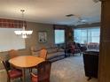 Cozy living room with plush carpeting, comfortable seating, and a dining area at 2280 Bancroft S Cir # A, Palm Harbor, FL 34683