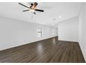 Spacious living room with dark laminate flooring and ceiling fan at 15098 Chimney Swift Rd, Brooksville, FL 34614