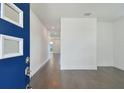 Bright entryway with a bold blue door, modern wood floors, and white walls at 1530 W River Shore Way, Tampa, FL 33603