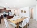 Bright dining area with a wood table and modern white chairs at 19231 Mossy Pine Dr, Tampa, FL 33647
