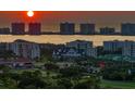 Stunning sunset view of the waterfront community showcasing lush greenery and cityscape at 3 Seaside Ln # 601, Belleair, FL 33756