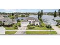 Aerial view of the home highlighting its landscaped yard and water views at 5556 Sabal Trace Dr, North Port, FL 34287