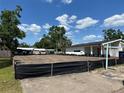 A sunny vacant lot, surrounded with a construction fence, awaits a new home next to a modern house at 809 W Indiana Ave, Tampa, FL 33603