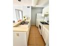 Efficient kitchen featuring white appliances and cabinets, tile backsplash, and a double stainless steel sink at 10024 Strafford Oak Ct # 815, Tampa, FL 33624