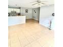Bright living room area with ceiling fan, tiled flooring, and view into the kitchen and breakfast bar at 10024 Strafford Oak Ct # 815, Tampa, FL 33624