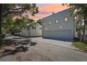 Backyard of the home with a brick driveway and a view of the garage under a colorful evening sky at 1412 S Moody Ave # A, Tampa, FL 33629