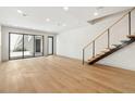 Bright, open-concept living area with hardwood floors, modern staircase, and sliding glass doors at 1412 S Moody Ave # A, Tampa, FL 33629