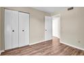 Simple bedroom with wood-look floors and mirrored closet doors at 1799 N Highland Ave # 28, Clearwater, FL 33755