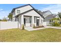 Inviting front exterior of a white house with a covered porch, landscaping, and a fenced yard at 3006 E Columbus Dr, Tampa, FL 33605