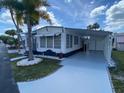 Front view of a renovated manufactured home with a carport at 4851 W Gandy Blvd # B10L30, Tampa, FL 33611