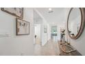 Bright entryway features tile flooring, neutral walls, and an elegant mirror that adds a touch of sophistication at 706 Ace Outlaw Ave, Ruskin, FL 33570