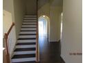 Elegant staircase with dark wood steps and white risers at 7423 Pulteney Dr, Zephyrhills, FL 33545