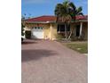 Welcoming home featuring a brick driveway and mature landscaping enhancing its curb appeal at 988 Bruce Ave, Clearwater Beach, FL 33767