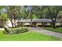 Attractive yellow house with lush landscaping and a long driveway at 136 Bay Point Ne Dr, St Petersburg, FL 33704