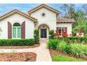 Front entrance with a blue door, arched entryway, and decorative shutters at 5212 Candler View Dr, Lithia, FL 33547