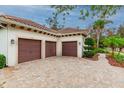 Attached three-car garage with brick-paved driveway and manicured landscaping enhancing the home's curb appeal at 5212 Candler View Dr, Lithia, FL 33547