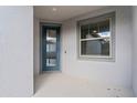 Front entryway with a dark-colored door, a window, and a small porch at 6421 Mooring Line Cir, Apollo Beach, FL 33572