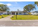 Inviting one-story home with a well-maintained lawn and a paved driveway at 9890 54Th N St, Pinellas Park, FL 33782