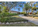 Circular driveway and lush landscaping lead to a single-Gathering home at 1304 N Jasmine Ave, Tarpon Springs, FL 34689