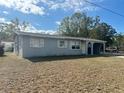 Front exterior of a single-story gray home with a carport and dry lawn at 1386 19Th St, Sarasota, FL 34234