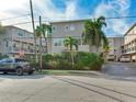Street view of a townhouse complex with palm trees and a 