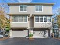 Front view of a two-unit townhouse featuring two garages and some shrubs at 2606 Espana Ct, Tampa, FL 33609