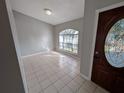 Bright entryway with tile flooring, an arched window, and a decorative glass front door at 27355 Breakers Dr, Wesley Chapel, FL 33544