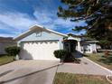 Front exterior of a single-story home with a three-car garage and landscaped yard at 27355 Breakers Dr, Wesley Chapel, FL 33544