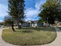 Inviting light blue single-story house nestled on a corner lot with mature trees and landscaping at 27355 Breakers Dr, Wesley Chapel, FL 33544