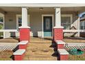 Inviting front porch with red brick columns, a porch swing, and a teal front door at 307 W Frierson Ave, Tampa, FL 33603