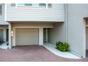 Front exterior of the condo with garage access, brick driveway, and landscaping at 370 Pinellas Bayway S # E, Tierra Verde, FL 33715