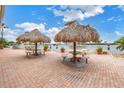 Relaxing patio area with thatched umbrellas and picnic tables at 4775 Cove Cir # 904, St Petersburg, FL 33708