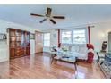Living room with ceiling fan, wood-look tile floors, and lots of natural light at 5624 Mccoy Ct, Zephyrhills, FL 33542