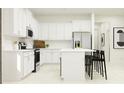 Modern white kitchen with stainless steel appliances, an island, and white countertops at 12617 Lily Quartz Loop, Parrish, FL 34219