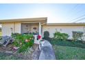 Charming condo exterior featuring a screened porch and well-maintained landscaping at 1901 Canterbury Ln # 19, Sun City Center, FL 33573