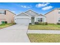 Gray and white single-story house with a two-car garage and well-maintained lawn at 33510 Elm Hill Branch, Wesley Chapel, FL 33545