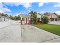 White home with red brick accents, driveway, and green lawn at 3709 N Darwin Ave, Tampa, FL 33603