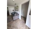 Living room with gray sofa, patterned rug, and access to another room at 644 Blue Nw Ln, Port Charlotte, FL 33952