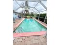 In-ground pool with a screened enclosure, surrounded by palm trees and greenery at 644 Blue Nw Ln, Port Charlotte, FL 33952