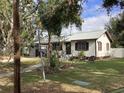 Quaint home with a lush front lawn, cozy seating, and charming shutters at 1529 Paloma Ln, Dunedin, FL 34698