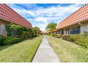 Sidewalk lined with lush landscaping leads through a picturesque community at 19029 Us Highway 19 # 25D, Clearwater, FL 33764