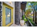 Bright yellow front door with stone accents and potted plant at 4810 W Mcelroy Ave # 2, Tampa, FL 33611