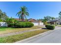 Exterior view of a house with palm trees, shrubs, and a white fence at 5875 Bay Pines Lakes Blvd, St Petersburg, FL 33708