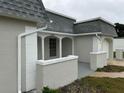 Side view of a single-story house with a gray roof and white and gray walls at 3349 Overland Dr, Holiday, FL 34691