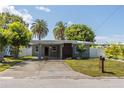 Front view of a single-story home with a driveway, landscaping, and palm trees at 341 Bahia Vista Dr, Indian Rocks Beach, FL 33785