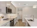 Modern kitchen featuring stainless steel appliances, white countertops, and ample cabinet space at 4098 Snail Cork Pl, Lutz, FL 33559