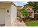 Inviting home entrance with brick pathway and a lush tropical landscaping and front door awning at 4327 Murfield E Dr, Bradenton, FL 34203