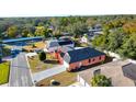 An aerial view of a home with solar panels, surrounded by trees and neighboring houses at 4401 Plumosa St, Spring Hill, FL 34607
