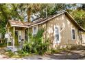 Side view of the single-story home with porch and landscaping at 8303 N Mulberry St, Tampa, FL 33604